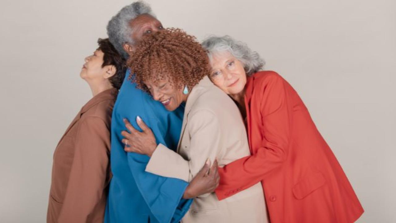 Four senior women holding in an embrace