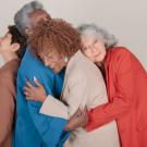 Four senior women holding in an embrace