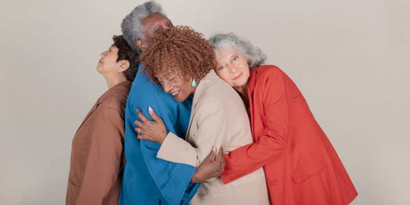Four senior women holding in an embrace